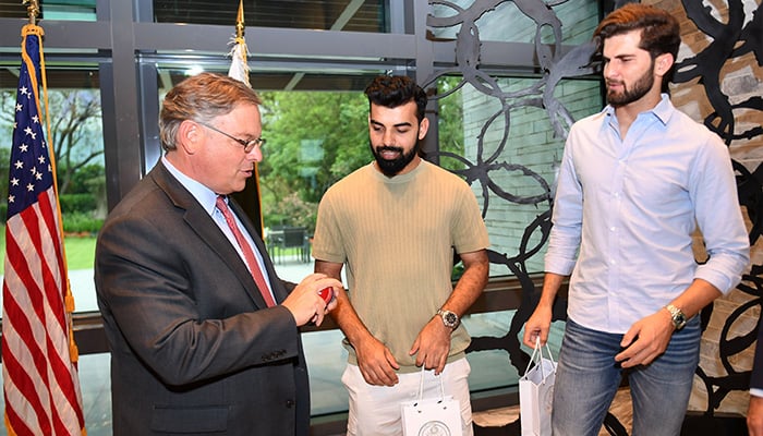 Pakistani players Shaheen Afridi and Shadab Khan standing with US ambassador Donald Blome at US Embassy in this undated photo. — X/@usembislamabad