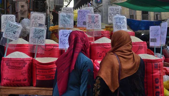 Women check rice prices at a main wholesale market in Karachi. — AFP/File