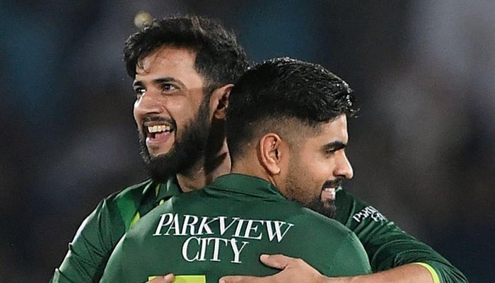 Imad Wasim hugs Babar Azam during a match in this undated photo. — AFP
