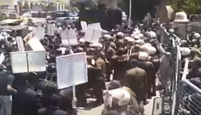 Lawyers seen gathered around a police van in Lahore on May 8, 2024, in this still taken from a video. — YouTube/Geo News Live
