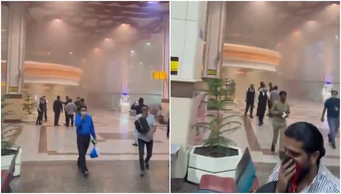 Passengers walking amid smoke after massive fire broke out at Allama Iqbal International Airport on May 9, 2024. — Screengrab/X/@ghulamabbasshah