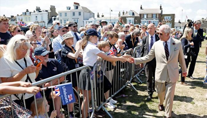 King Charles greeting well-wishers, exchanging laughs, and warm handshakes.