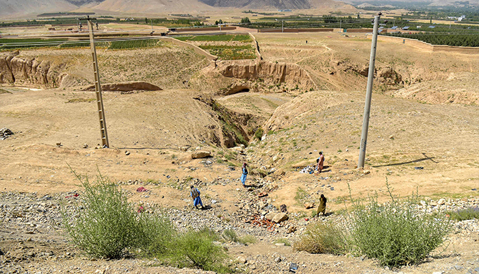 Afghans stand at the accident site, after a passenger bus overturned on the Kabul-Kandahar highway, on the outskirts of Maidan Wardak province on August 27, 2025. — AFP