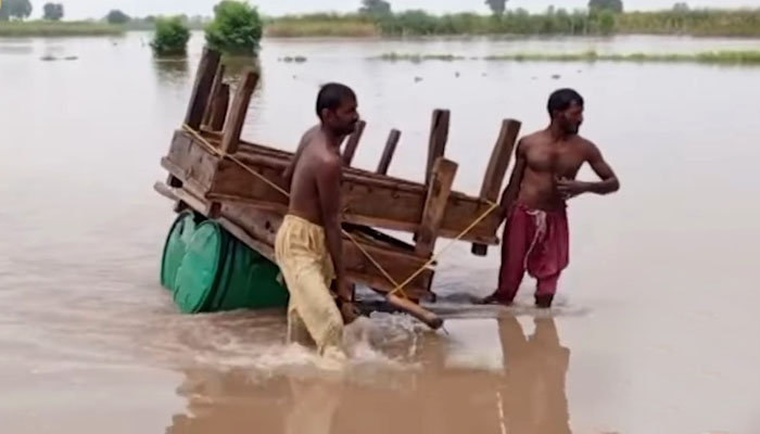 Flood-affected residents in Bahawalnagar struggle to move their household belongings to safer places. — Screengrab via Geo News