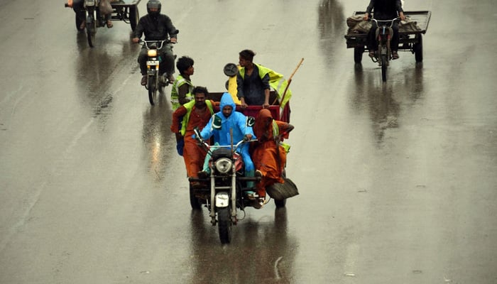 Motorists are on their way during rainfall in Karachi. — Online/File