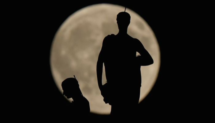The Harvest Supermoon rises behind spires of the Duomo gothic cathedral, Milan