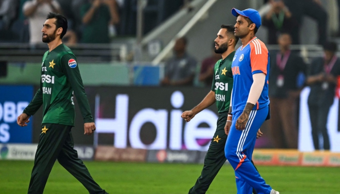 Indias captain Suryakumar Yadav (Right) and his Pakistani counterpart Salman Agha (Left) walk to the field before the start of the Asia Cup 2025 final at the Dubai International Stadium on September 28, 2025. — AFP