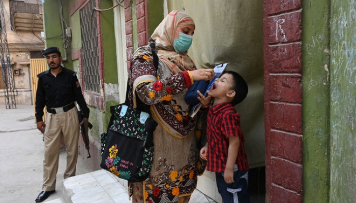 A health worker administers polio vaccine drops to a child during a vaccination campaign in Peshawar. — AFP/File