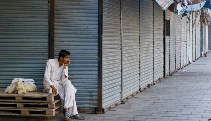 The representational image shows a man sitting beside closed shops during a strike against recent price increases, in Karachi, Pakistan, February 27, 2023. — Reuters
