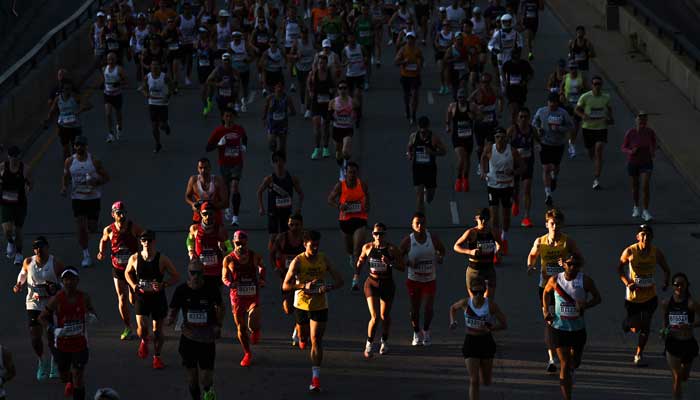 Waves of runners make their way through the 2025 Bank of America Chicago Marathon course in Chicago, Illinois on October 12, 2025. - AFP