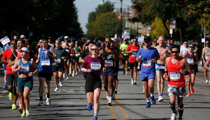 Participants run through the Pilsen neighborhood during the 2025 Chicago Marathon in Chicago, Ilinois, on October 12, 2025. - AFP