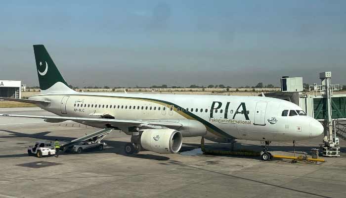 View of a Pakistan International Airlines (PIA) passenger plane, taken through a glass panel, at Islamabad International Airport, October 3, 2023. — Reuters