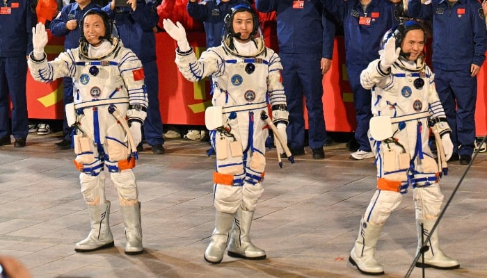 Astronauts for Chinas Shenzhou-21 space mission Commander Zhang Lu (R), Wu Fei (C) and Zhang Hongzhang (L) walk during a departure ceremony before boarding a bus to take them to the Shenzhou-21 spaceship at the Jiuquan Satellite Launch Centre in the Gobi Desert in northwest China on October 31, 2025. — AFP