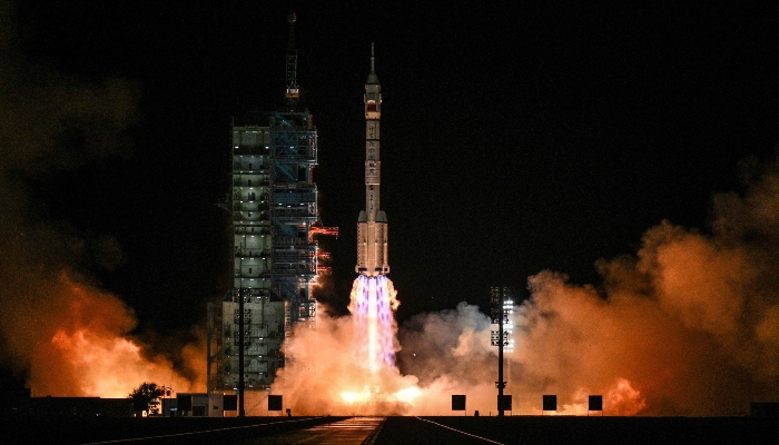 A Long March-2F launch vehicle, carrying the Shenzhou-21 spacecraft and a crew of three astronauts, lifts off from the Jiuquan Satellite Launch Center in the Gobi Desert, northwest China, on October 31, 2025. – AFP