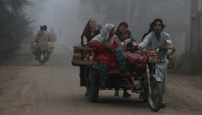 A family moves on a trishaw along a road on a smoggy morning on the outskirts of Multan, Pakistan, November 11, 2024. — Reuters