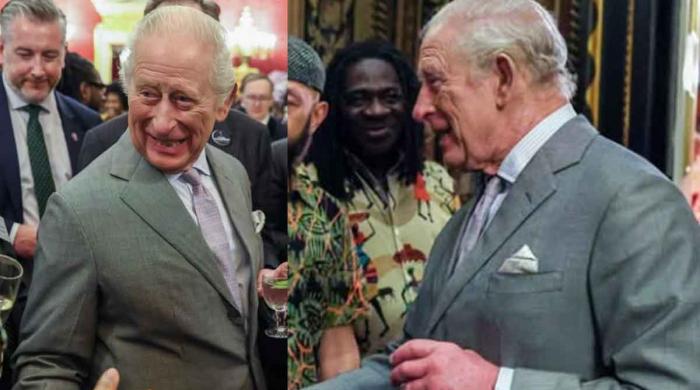With a drink in hand, King Charles looks happy at palace event 