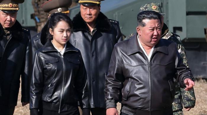 North Korean leader Kim Jong Un shares rare public moment with daughter on tank ride during military display 