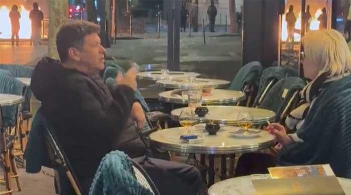 French couple go viral as they keep drinking and smoking amid destruction of Paris 
